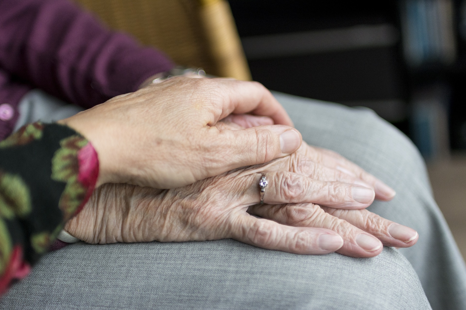 Close up image of a female with her hand on an older female's hand