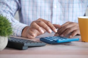 Close up image of a man using a calculator